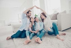 family sitting together making the shape of a home
