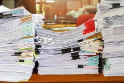 Stacks of paperwork piled on desk
