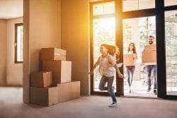 family moving boxes in new home child running in first
