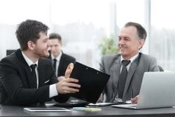 businessmen meeting and going over items on a tablet