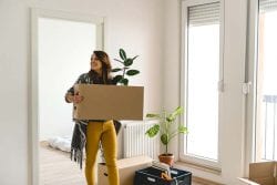 woman moving a box into new apartment